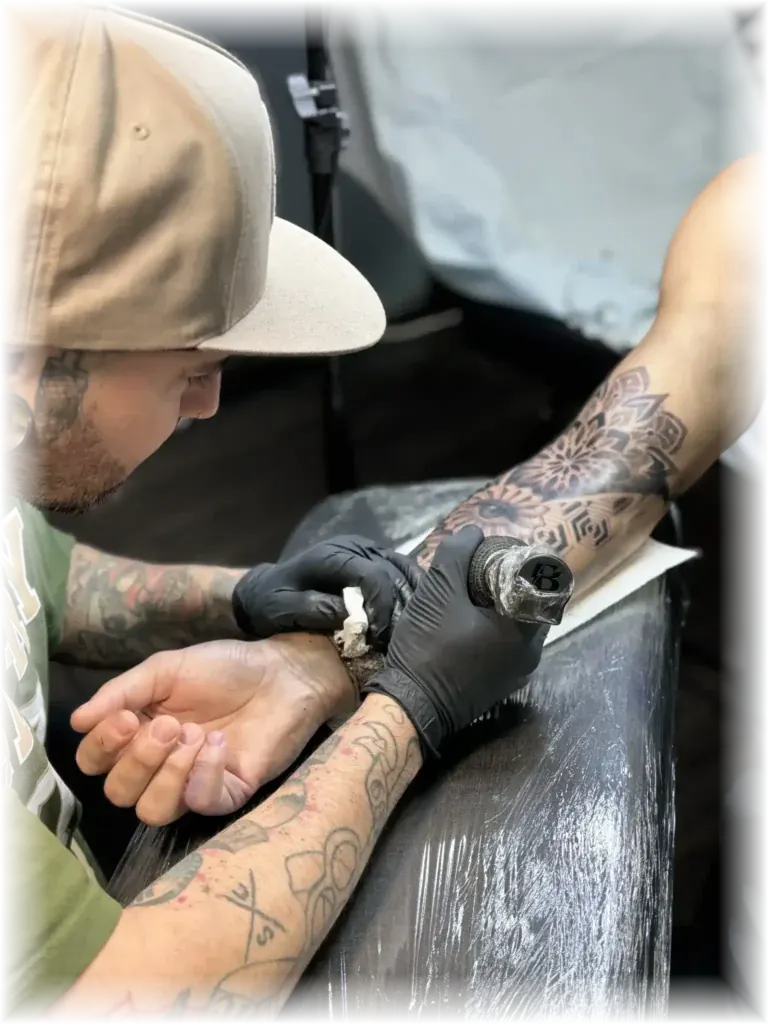 Close-up of Duk Tattoo tattooing a forearm with precision in Boca Raton, Florida