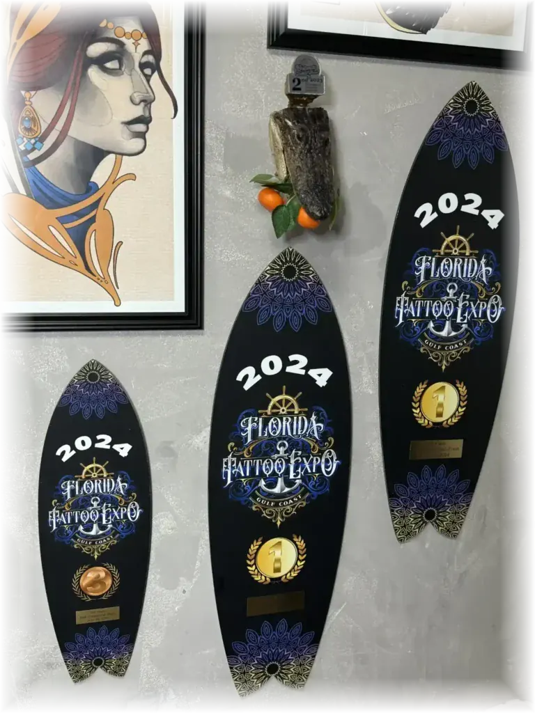 Florida Tattoo Expo trophies won by Duk Tattoo displayed on his studio wall in Boca Raton