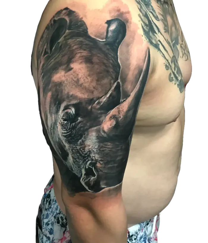 Black and grey realism rhino tattoo on the shoulder and upper arm by Duk Tattoo, Boca Raton